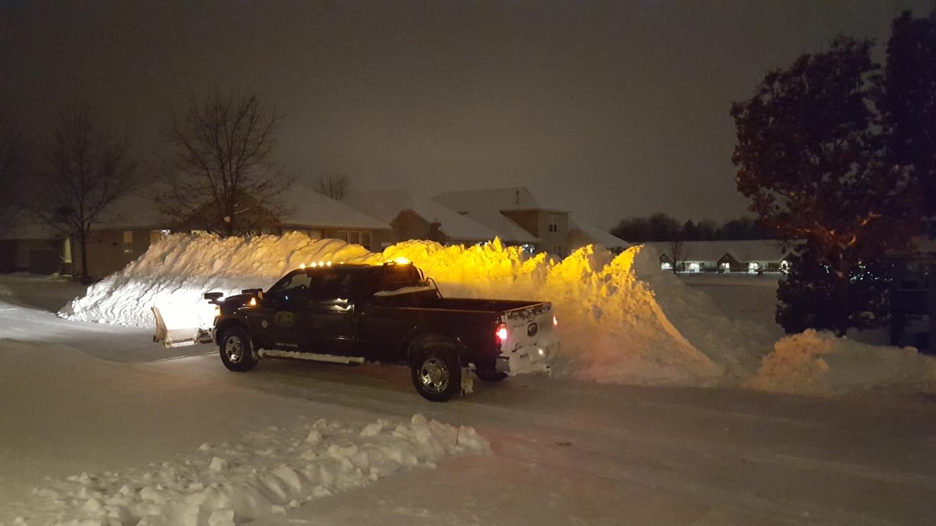 truck plowing snow at night