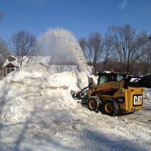 mini excavator plowing snow